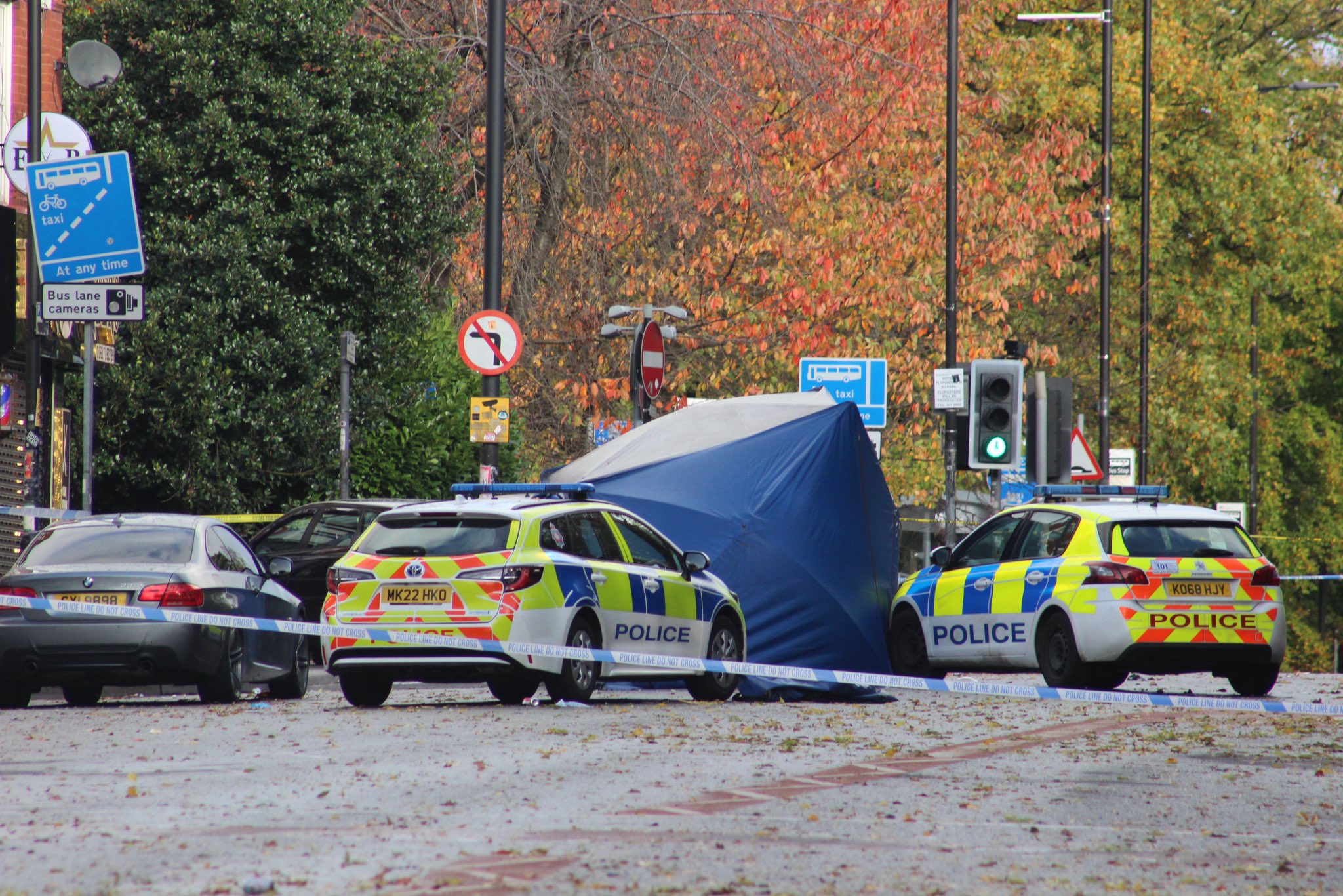 Police cars line the streets of Wilmslow Road after murder