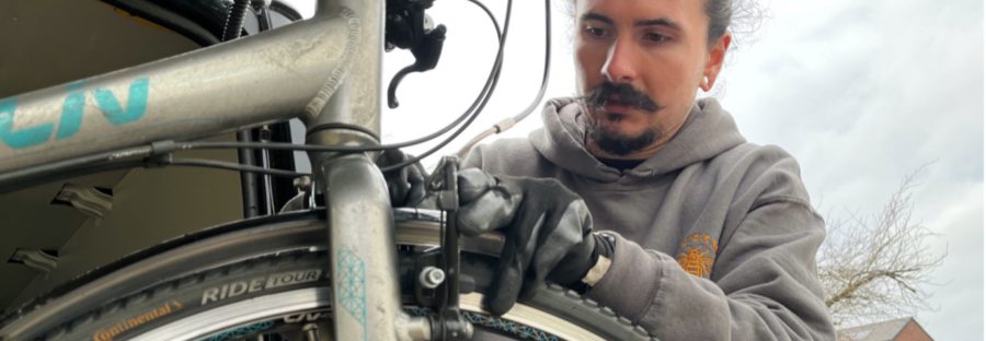 Joe Rostern repairs bike for bike libraries programme