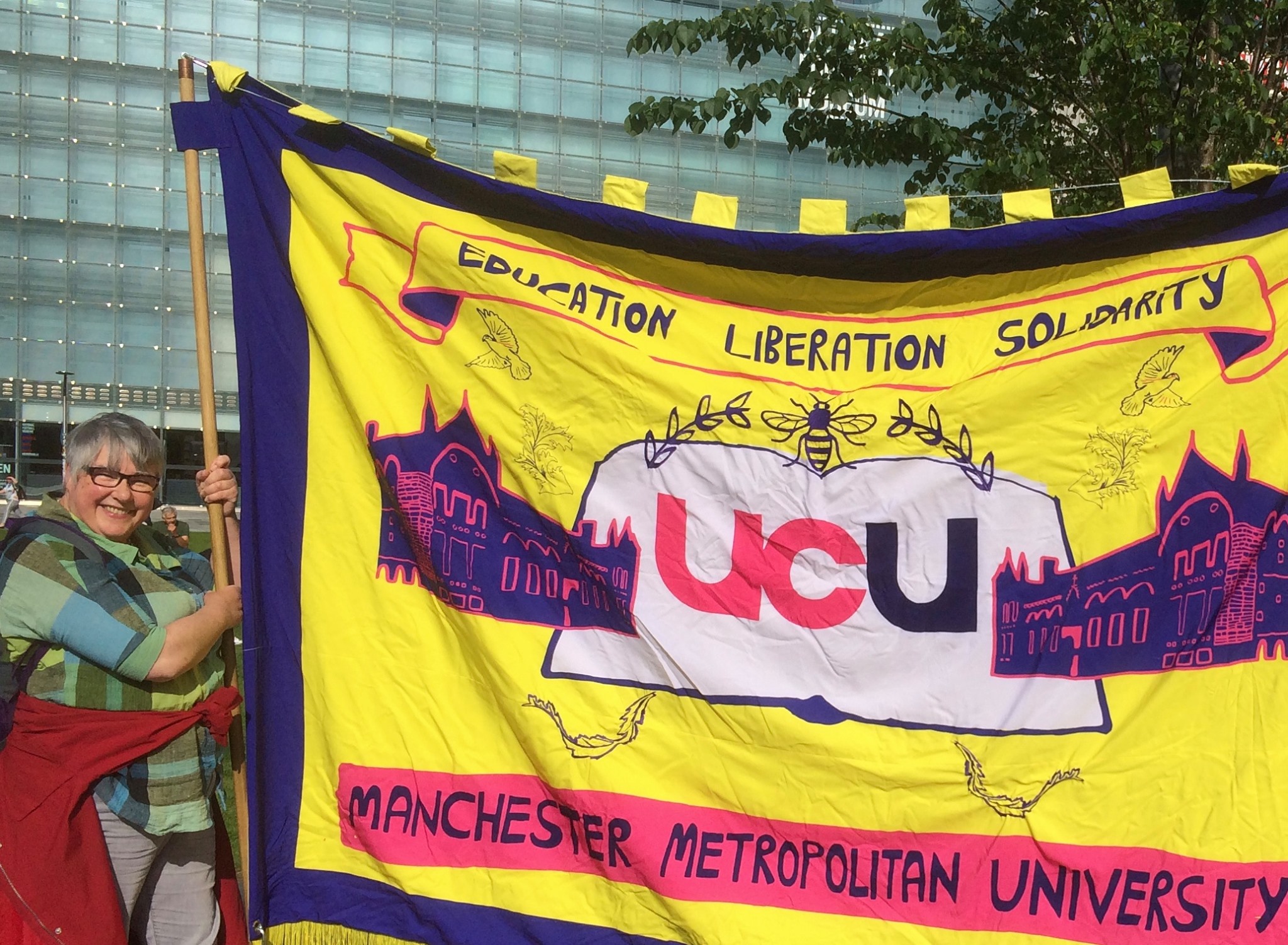 UCU secretary Julie Wilkinson holding aloft union flag at a demonstration