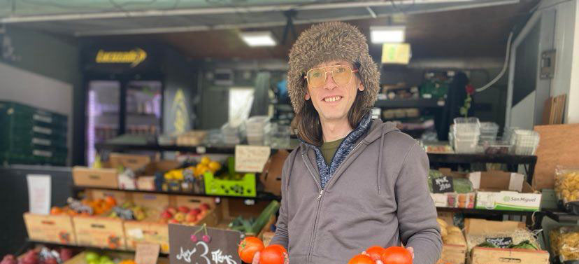 Stallholder Daniel Smith holds up a bunch of red tomatoes