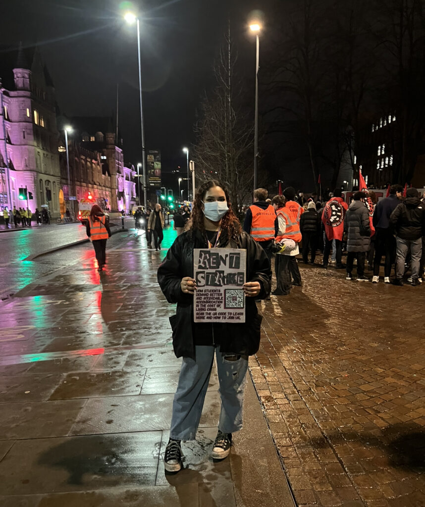 A student protestor at the rent strike march holds up a placard