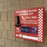 Red emergency bleed control box with white writing and a pin code