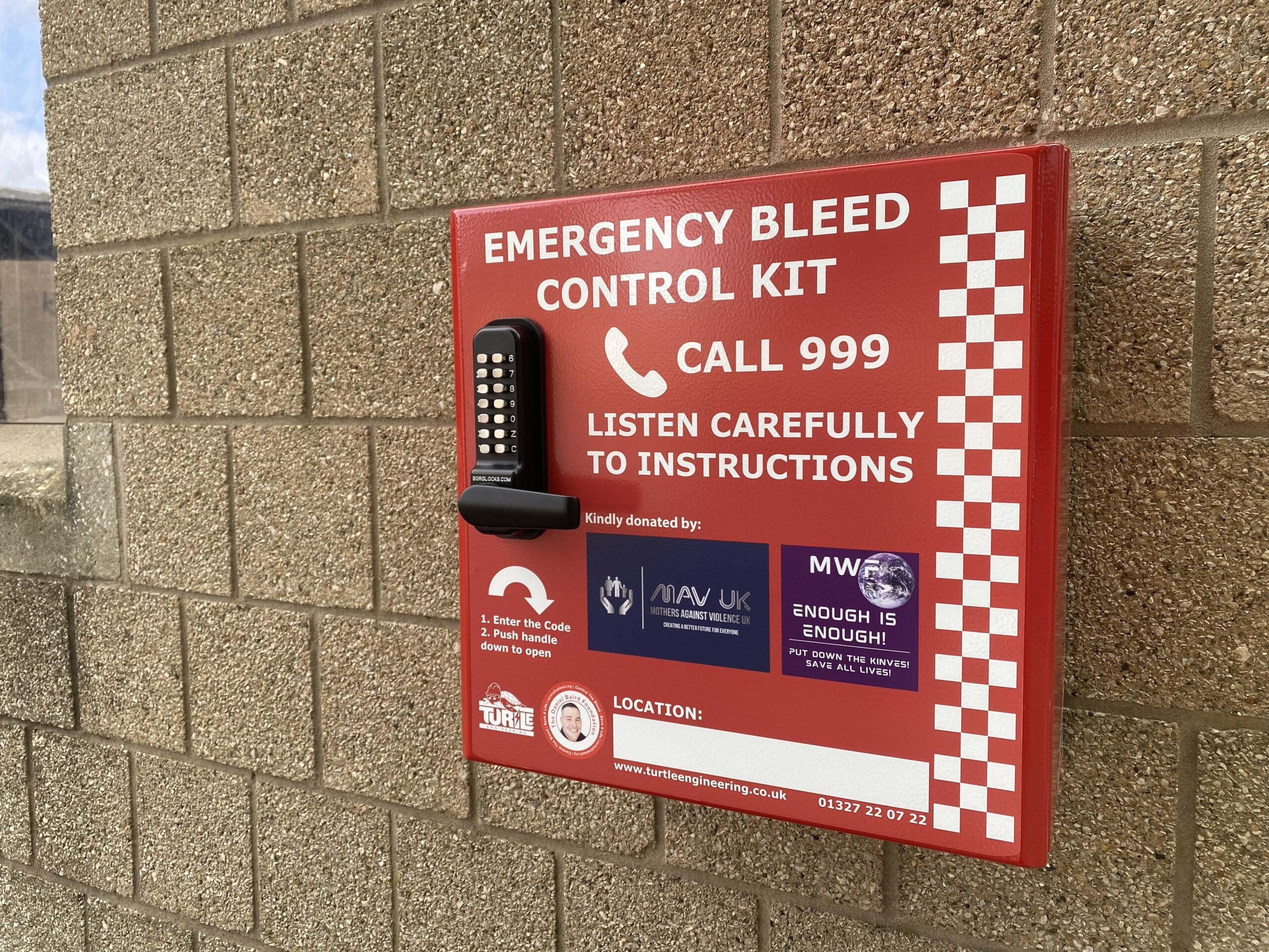 Red emergency bleed control box with white writing and a pin code