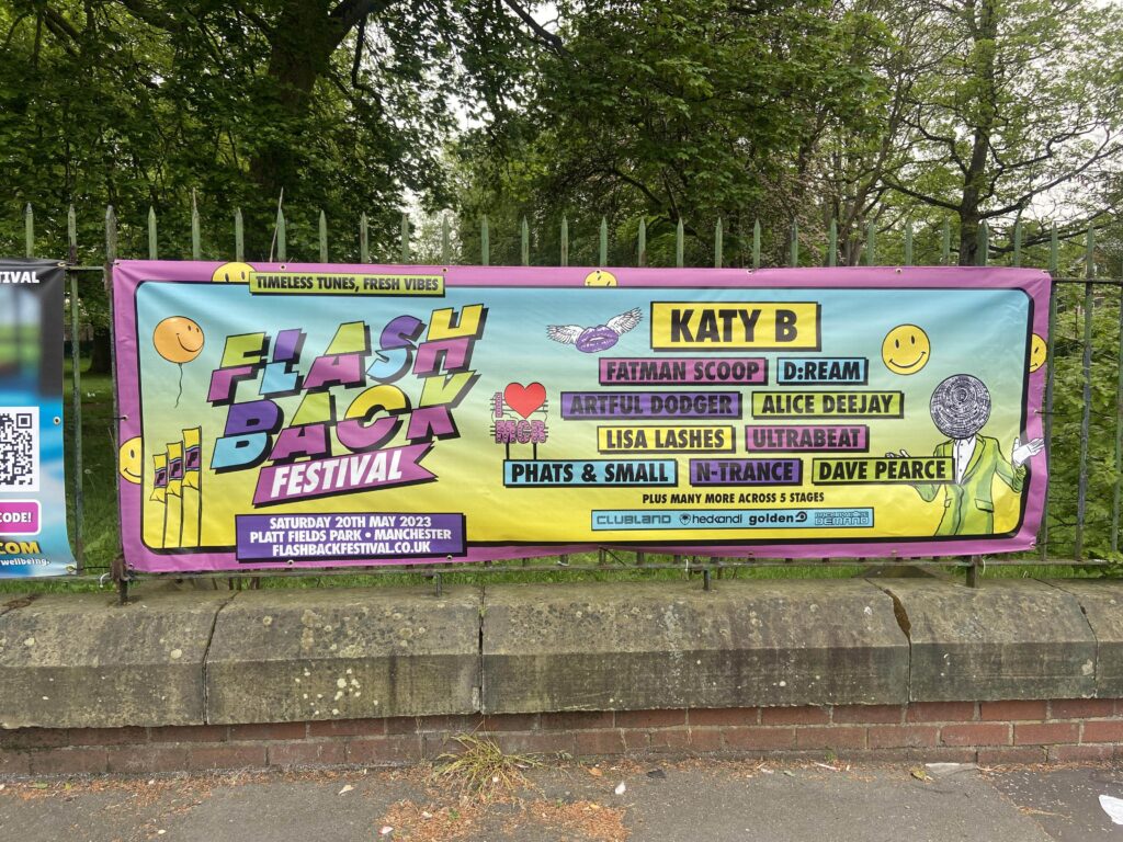 Promotional poster outside of Platt Fields Park with this years line up for Flashback Festival.
