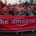 protestors holding a banner saying Make Amazon Pay