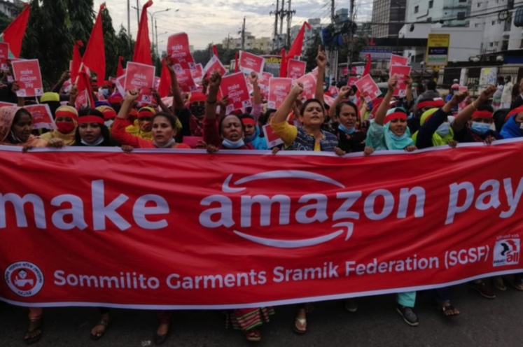 protestors holding a banner saying Make Amazon Pay