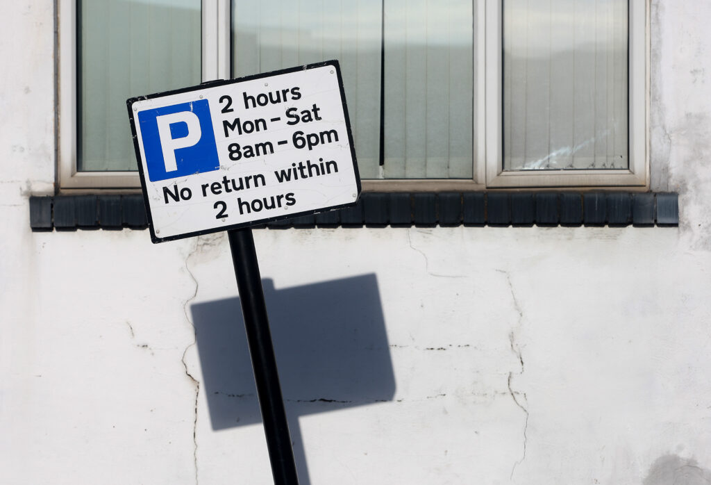 Parking restrictions sign that says 'no return within 2 hours'