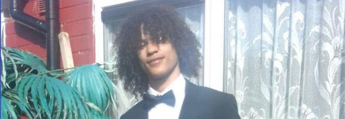 Devonte Scott. He is stood outside his house wearing a tuxedo and smiling at the camera.