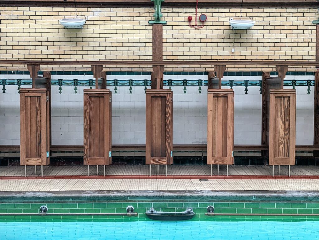 Original wooden changing rooms at side of the pool still in use. 