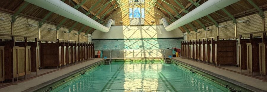 Withington Baths interior with pool and refurbished roof. Light reflects in pool water.