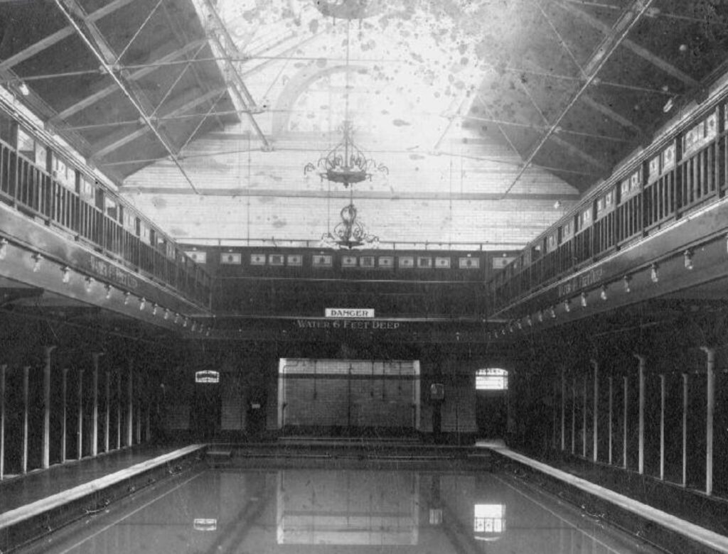 Black and white photo of how Withington Baths appeared in 1913 with original balcony above pool.