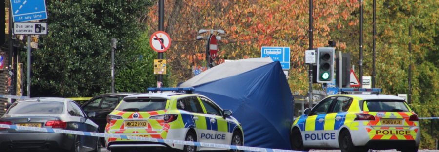 Police cars line the streets of Wilmslow Road after murder