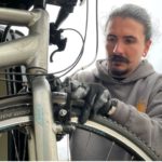 Joe Rostern repairs bike for bike libraries programme