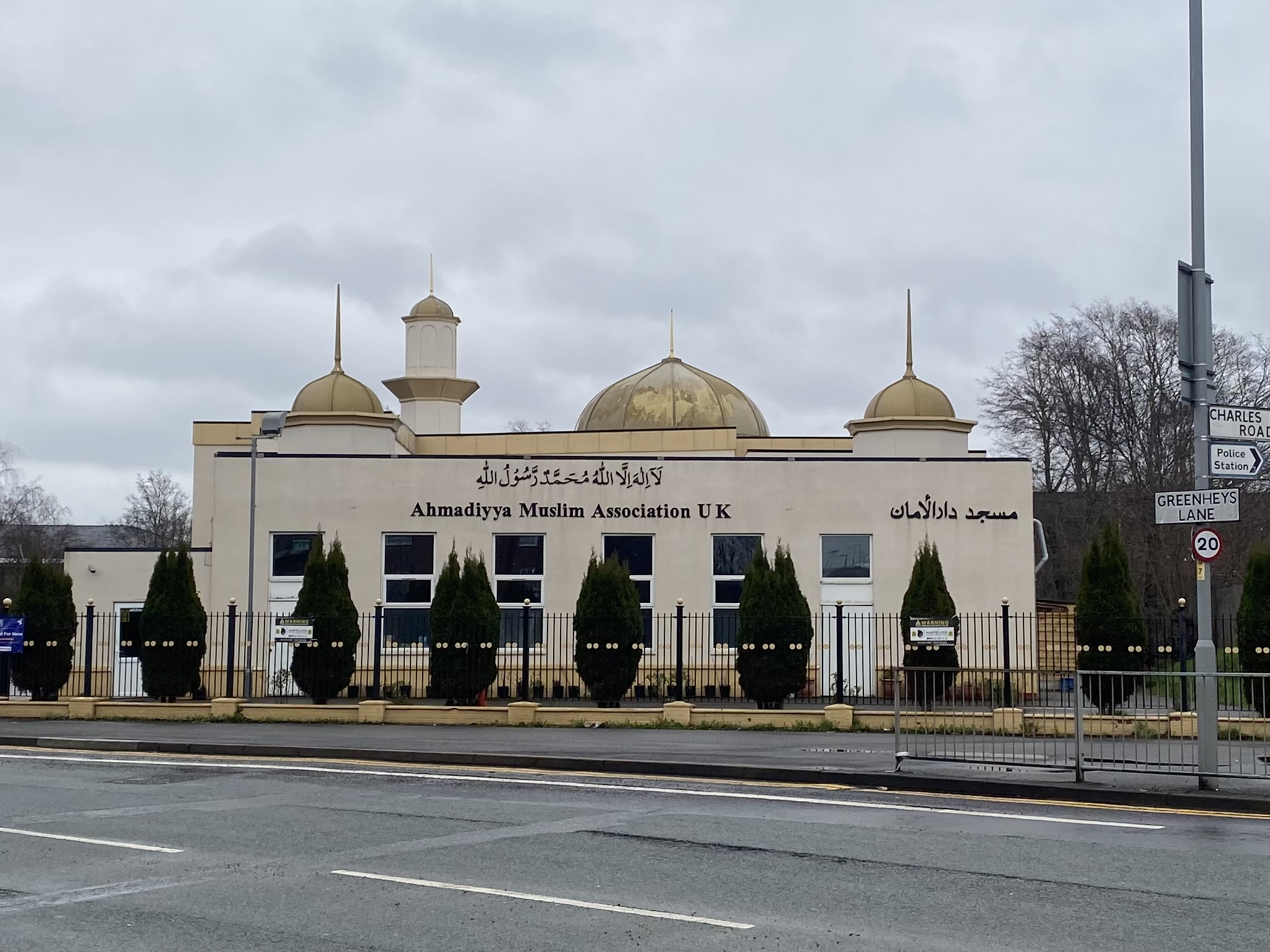 Beige coloured Mosque with gold accents, next to a road
