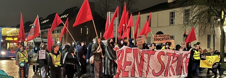 Student waving placards and banners march down Wilmslow Road
