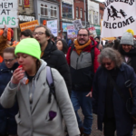 workers marching down Oxford Road during strike action for better pay.