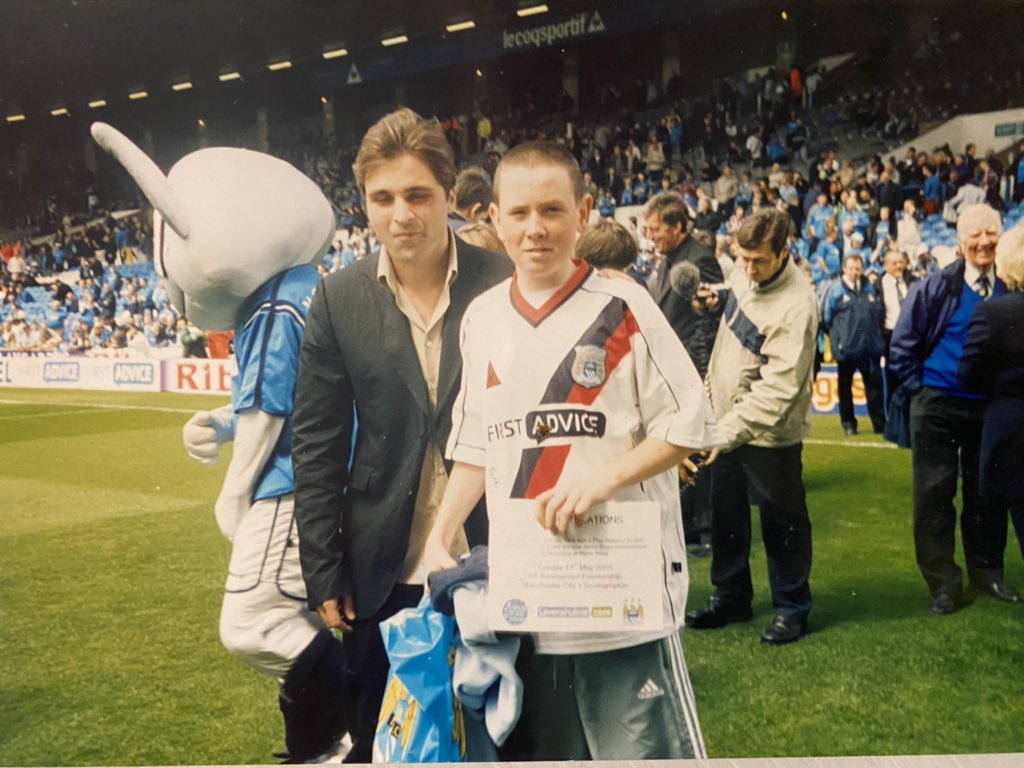 Man and boy on the grounds of Maine Road football stadium.
