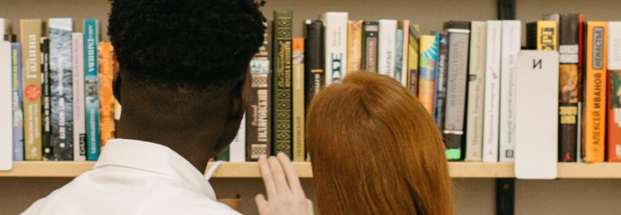 Books for lovers - a coulple with their back to the camera looking at books. Yaroslav Shurgev - 6281049