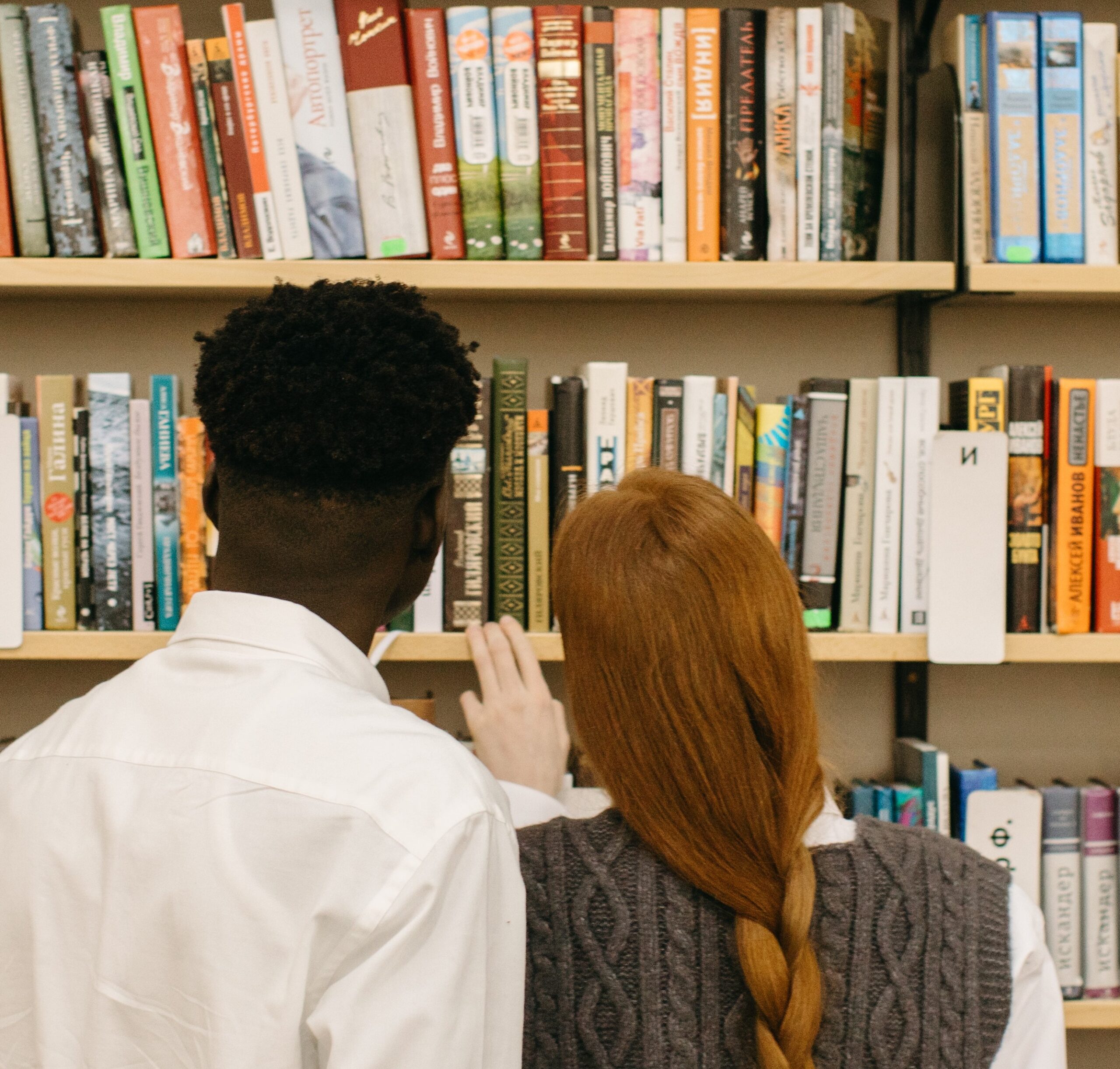 Books for lovers - a coulple with their back to the camera looking at books. Yaroslav Shurgev - 6281049