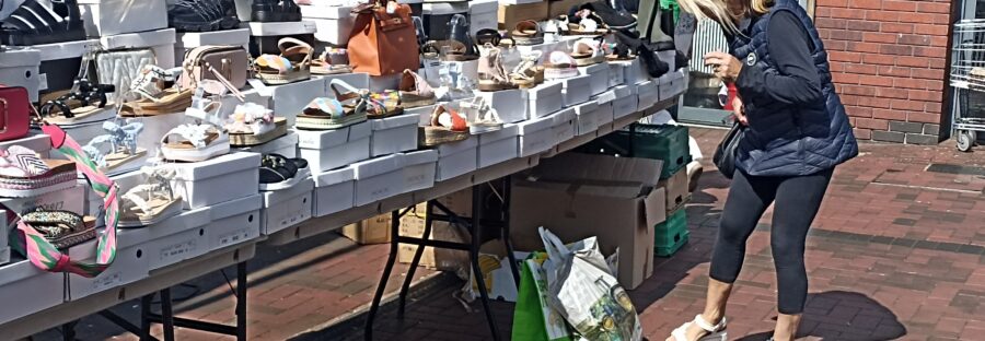A consumer fitting her summer footwear at Harpurhey Centre open market.