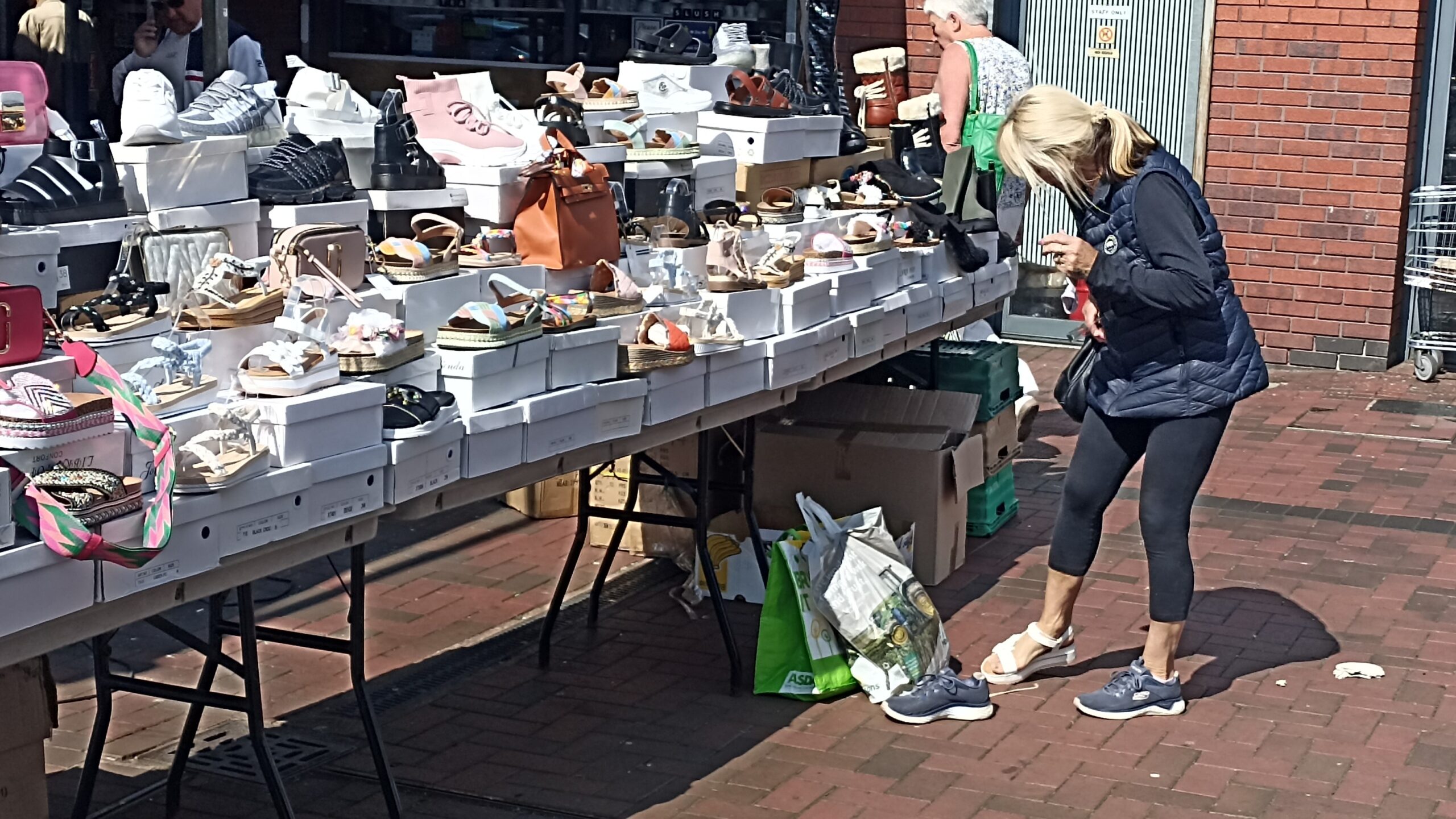 A consumer fitting her summer footwear at Harpurhey Centre open market.