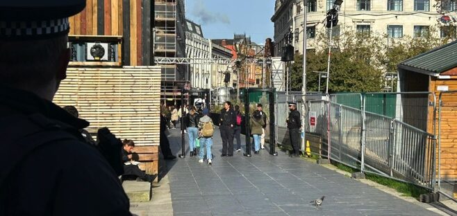 metal arches in Piccadilly Gardens, guarded by GMP