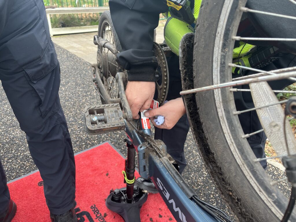 Photo of police officers in high-vis vests attaching a sticker to the underside of a bike.