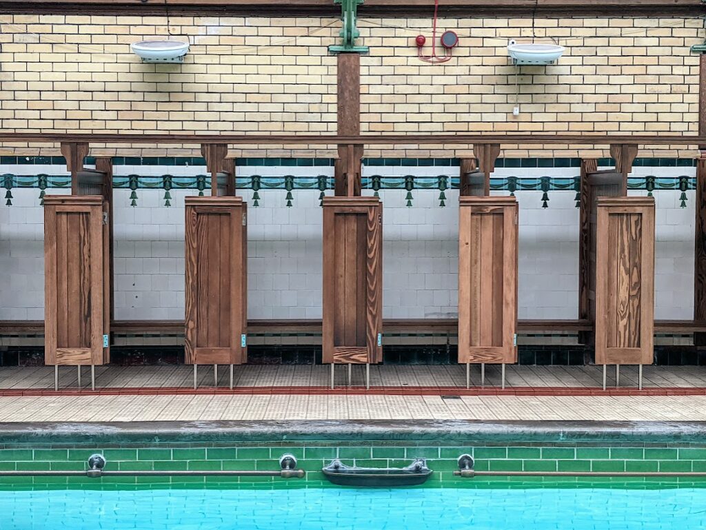 Original wooden changing rooms at side of the pool still in use.