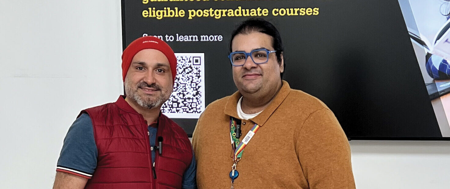 Faraz Arian (left) wears a red beanie and gilet over a blue shirt and grey ripped jeans. He is smiling at the camera and holding a sheet of paper. On the right of the image is Amraze Khan, who wears a yellow jumper and light jeans. He is also smiling into the camera.
