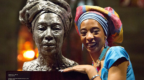 Professor Erinma Bell next to a bust of her