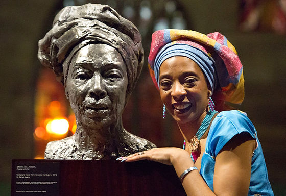 Professor Erinma Bell next to a bust of her