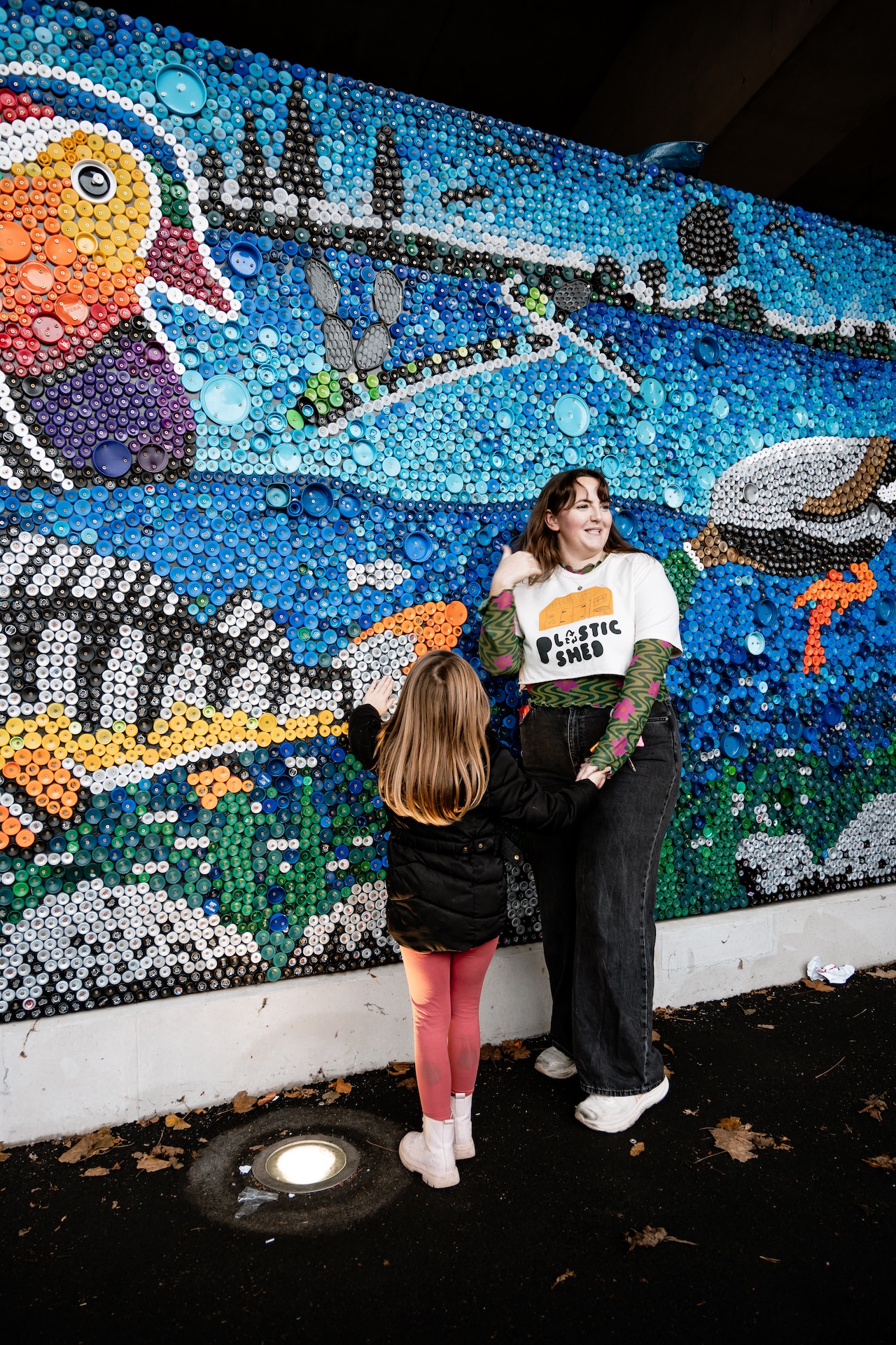 Artist (Caitlin) in front of the mural in Stockport