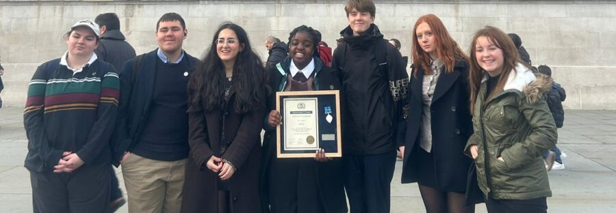 A group of people standing outside with an award