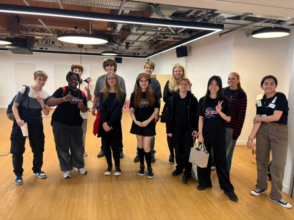 A group of people stood in a room smiling