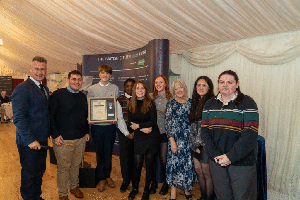 A group of people standing with an award
