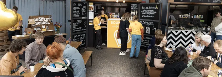 People sat down and stood outside a food stall