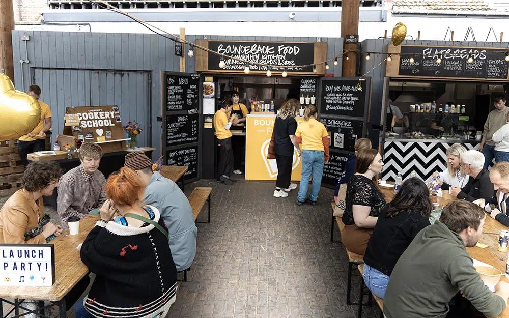 People sat down and stood outside a food stall