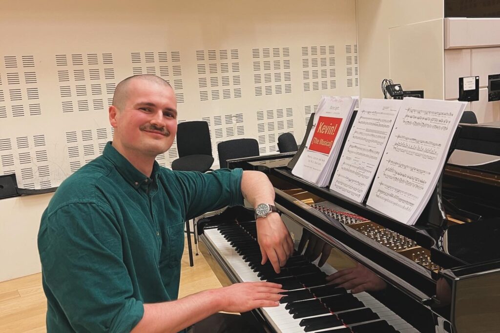 Man sat at a piano smiling